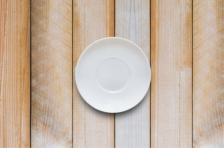empty white coffee plate put on wood board or wood table with clipping path and copy space.の写真素材