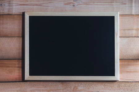 blank blackboard on wood table or blackboard hang on wood wall with copy space for text design.の写真素材