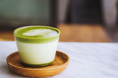 hot green tea late with modern style and delisious in wooden plate on marble table.の写真素材