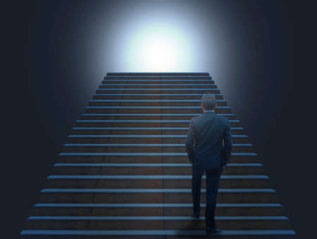 Businessman in suite walking on the stairsの写真素材