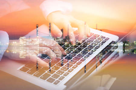 double exposure refinery and professional engineer worker business woman typing laptop keyboard working research and develop sustainable energy future oil fuel alternative resource project.の写真素材