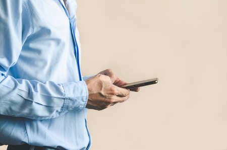 businessman using mobile phone touching screen in office with hands typing smart phone texting messaging lifestyle working app device technology internet social data online concept vintage style.の写真素材