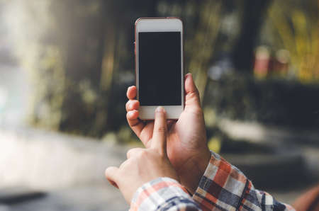 hipster woman using mobile phone touching screen at outdoor with hands typing smart phone texting...