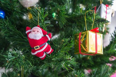 santa doll and present on pine tree