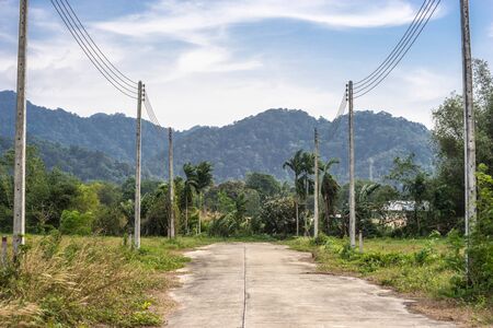 cement road and  electricity post, hil backgroundの写真素材