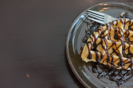 waffle ,choccolate topping on black plate , wooden black backgroundの写真素材