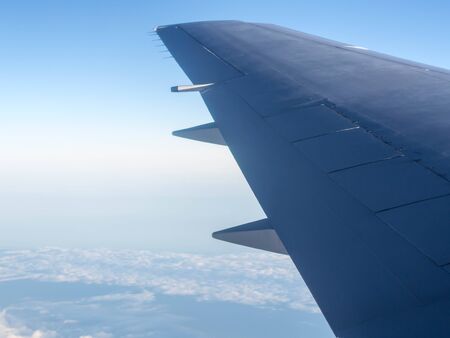 air plane wing above many cloud in blue sky , air plane window viewの写真素材