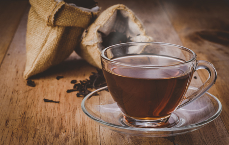 a cup of chinese tea on wooden table, hot drink with steam, vintage toneの写真素材