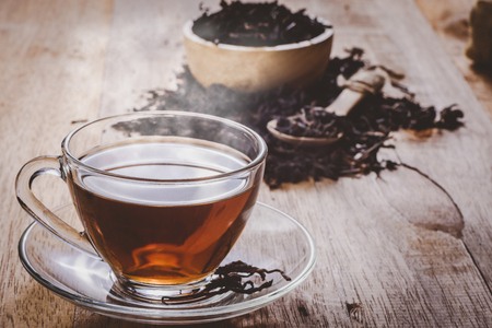 a cup of chinese tea on wooden table, hot drink with steam, vintage toneの写真素材