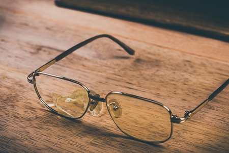 broken old glasses on wooden table, vintage toneの写真素材