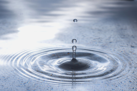 Abstract water drop in dirty metal tray and splash on surface make circle waveの写真素材
