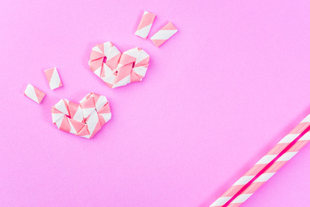 heart sign made from pink white straw on pink rubber foam sheet background, top viewの写真素材