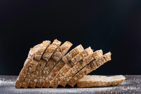 whole wheat bread with row on wooden table, black backgroundの写真素材