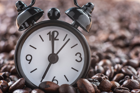 Close-up of alarm clock on coffee beans, serve for waking up