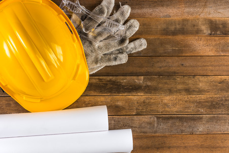 engineer or foreman safety helmet and equipment on wooden table, top view