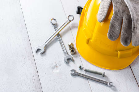 yellow safety helmet and tools on white wooden tableの写真素材