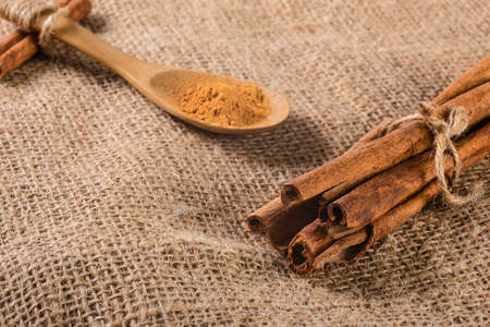 Close-up of cinnamon sticks tied with hemp rope on sackcloth