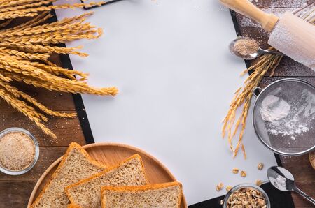 menu or recipe decorated with bread and ingredient for cooked on wooden table, blank white paper for...