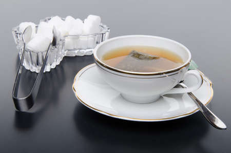 A cup of tea with sugar, on grey backgroundの写真素材