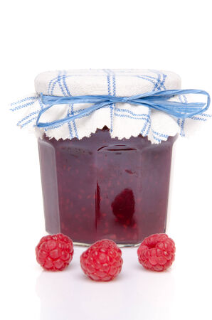Jar of raspberry jam with fresh raspberries, isolated on whiteの写真素材