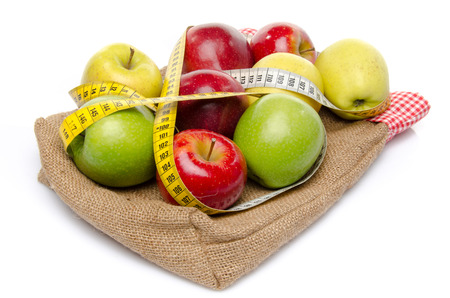 Four sorts of apple with a tape measure on a burlap bag, isolated on whiteの写真素材