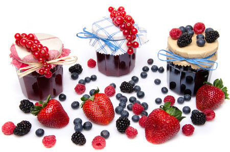 Composition with jars of red and black fruits jams and fresh fruits, isolated on whiteの写真素材