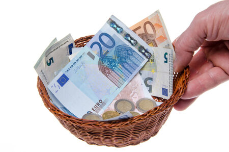 Hand holding a basket full of money, isolated on whiteの写真素材