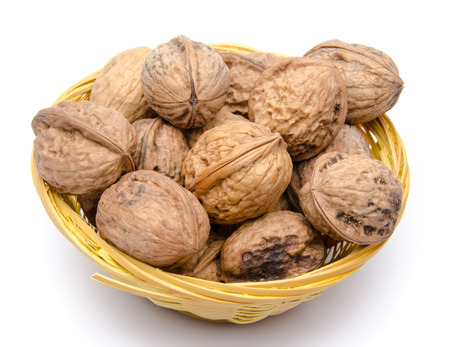 Walnuts in a basket, isolated on white