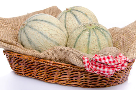 Melons in a basket, isolated on whiteの写真素材