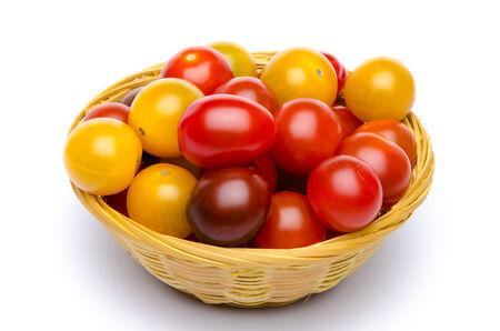 Different varieties of cherry tomatoes in a basket, isolated on whiteの写真素材