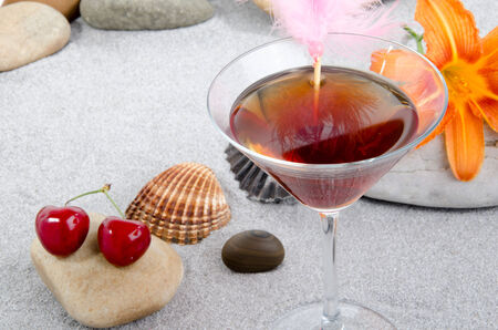 Composition with cherry cocktail on a sand backgroundの写真素材