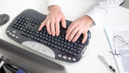 Man s hands typing on a keyboard