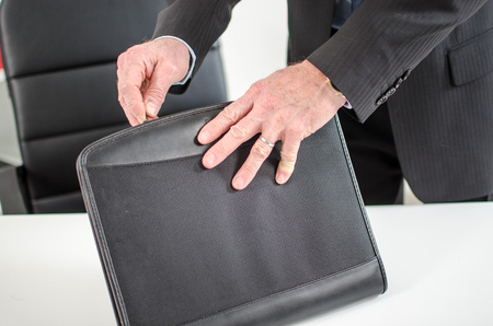 Businessman opening his briefcase on his deskの写真素材