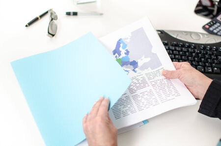 Woman s hand removing an economic document from a file folder