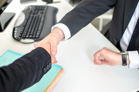 Concept of respect for working hours, manager shaking hands with an employeeの写真素材