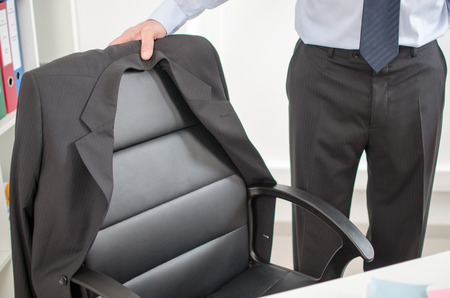 Businessman about to sit at his deskの写真素材
