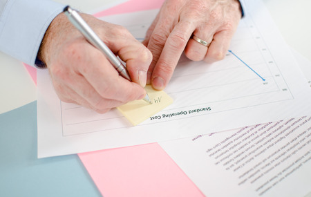 Man taking a note on a post it, closeupの写真素材