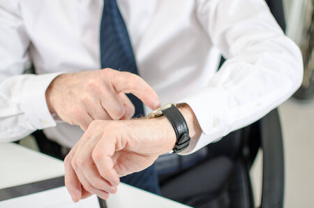 Businessman looking at his watch at officeの写真素材