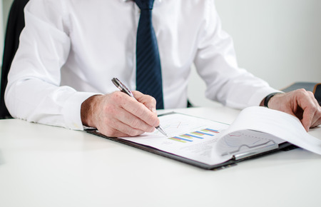 Businessman checking financial charts at office
