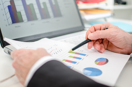 Businessman checking financial charts at officeの写真素材
