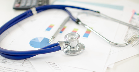 Stethoscope placed on financial chartsの写真素材