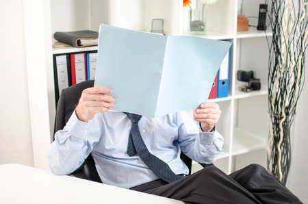 Relaxed businessman analyzing a document at officeの写真素材