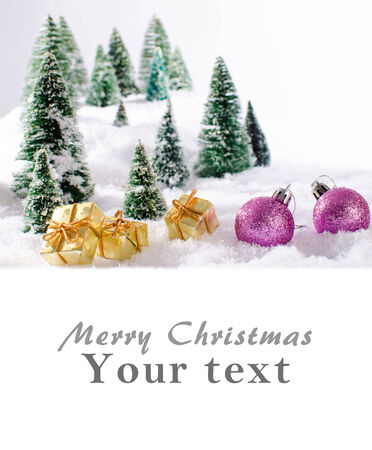 Christmas card showing a winter landscape with christmas balls and presentsの写真素材