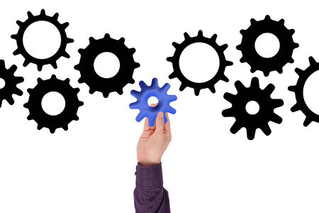 Hand holding a gearwheel, isolated on whiteの写真素材