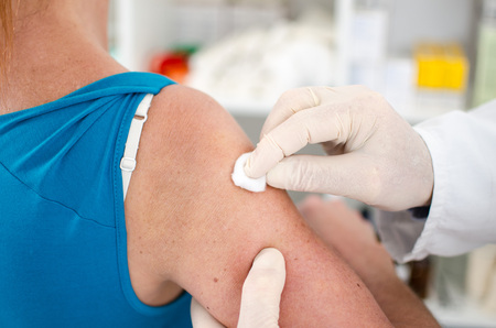 Doctor disinfecting the skin before an injectionの写真素材