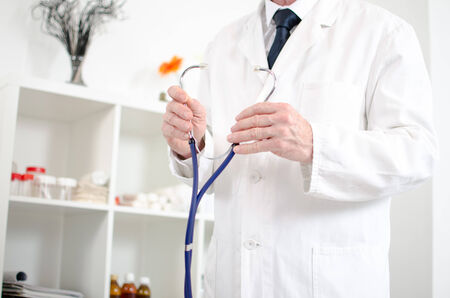 Doctor holding a stethoscope in his officeの写真素材