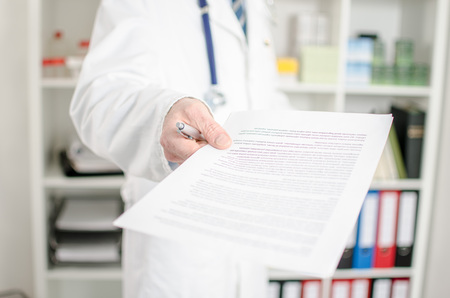 Doctor showing medical notes in his officeの写真素材