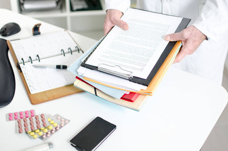 Doctor holding files in his officeの写真素材
