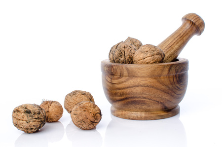Walnuts in a wooden mortar, isolated on white