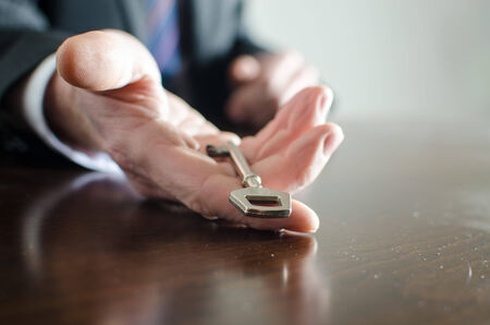 Businessman holding a key in his handの写真素材